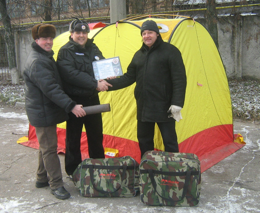 Петр Надточий (справа) по поручению Валерия Гнибеденко передает мобильную банию Мобиба МБ-25 представителям «Royal Rangers».
